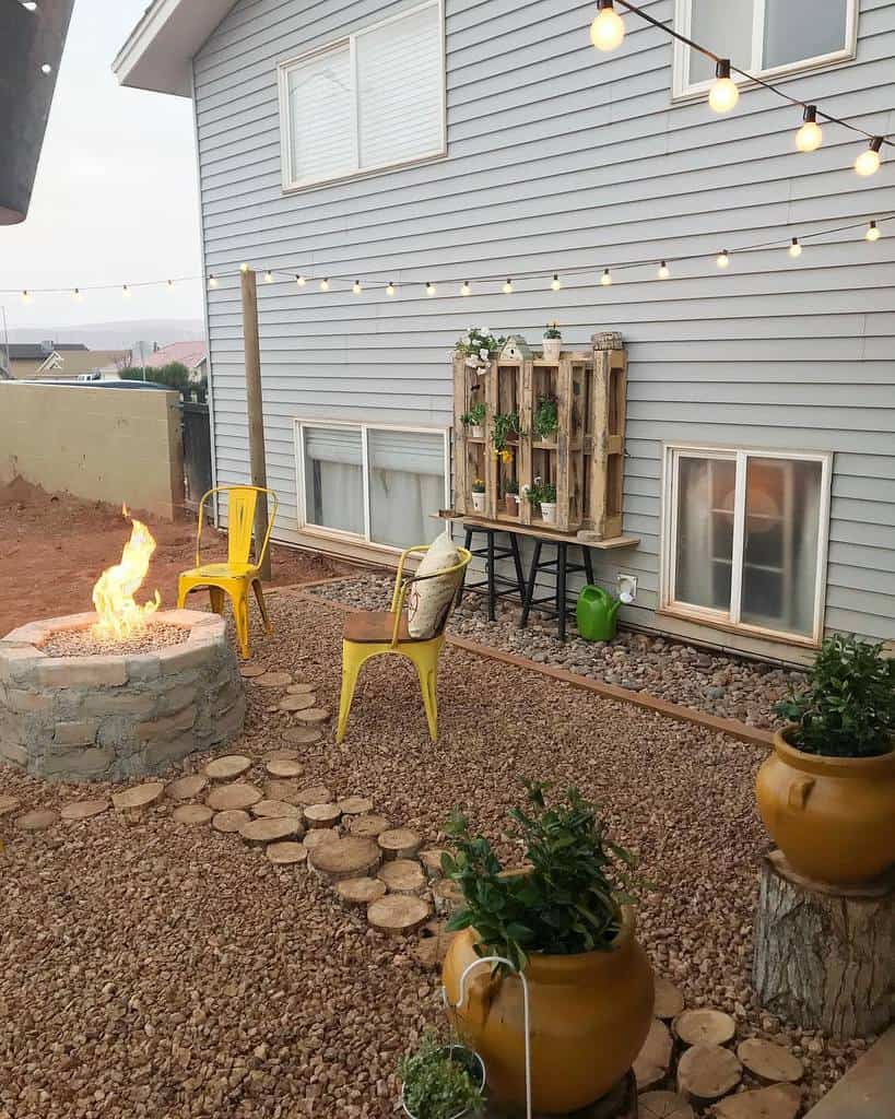 stone fire pit yellow chairs wood pallet planter hanging lights 