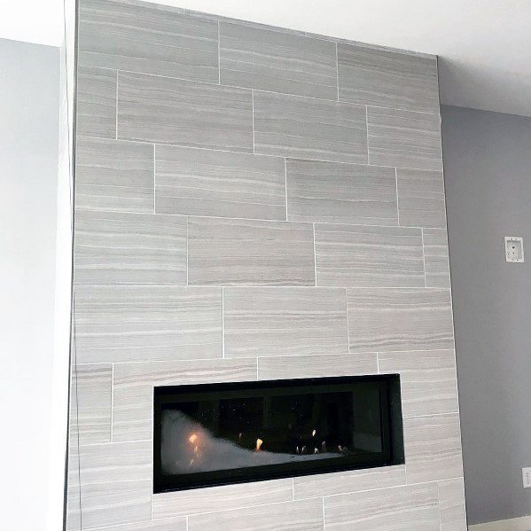 Contemporary fireplace with light gray horizontal tiles and a sleek linear gas insert.