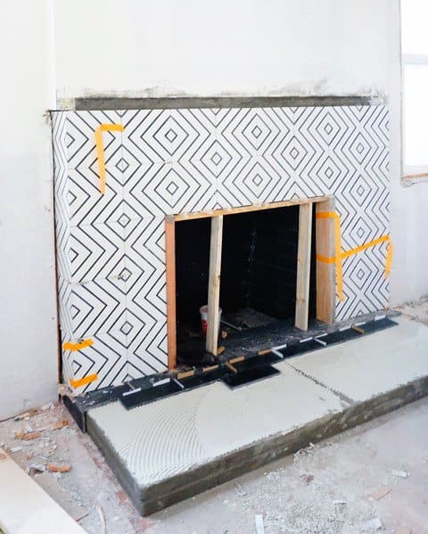 A bold fireplace design featuring geometric-patterned black and white tiles for a striking modern aesthetic.