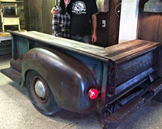 Rustic bar made from a vintage truck bed with a wooden countertop and industrial vibe.