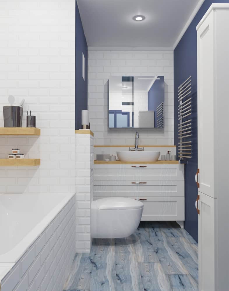 Blue and white bathroom with wooden accents, floating toilet, and modern vanity sink.