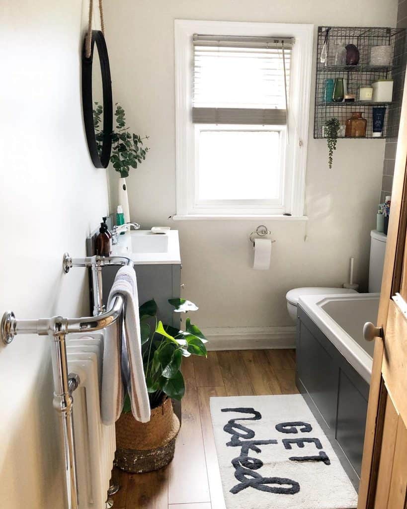 small bathroom with gray cabinet vanity and bathtub 