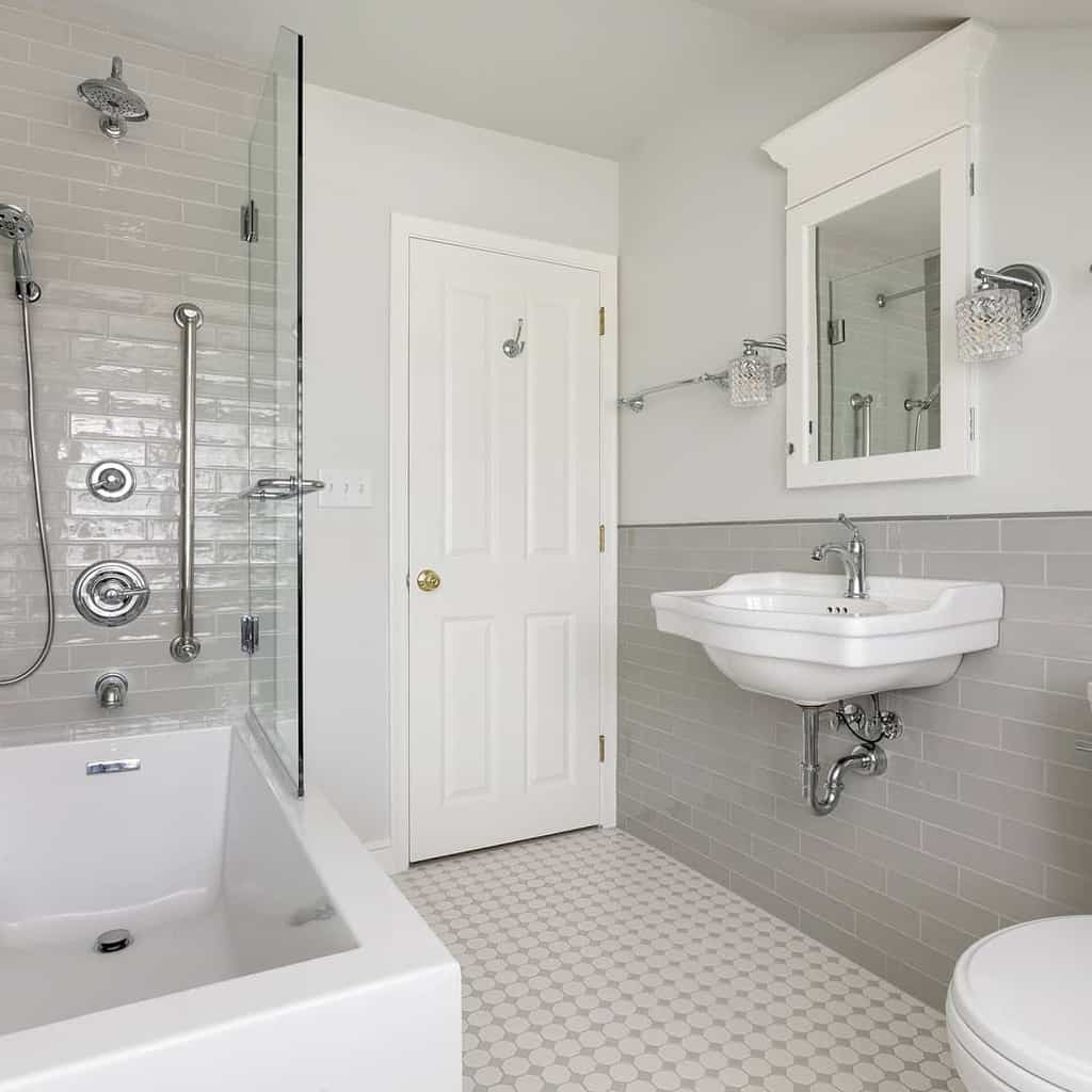 Simple white bathroom with subway tile walls, soaking tub, and wall-mounted sink.