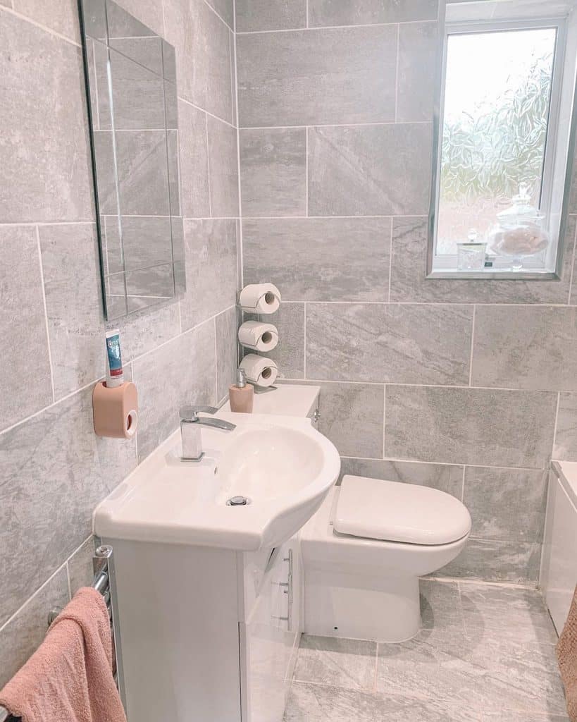 Contemporary bathroom with large slate tiles, compact sink, and minimalistic decor.