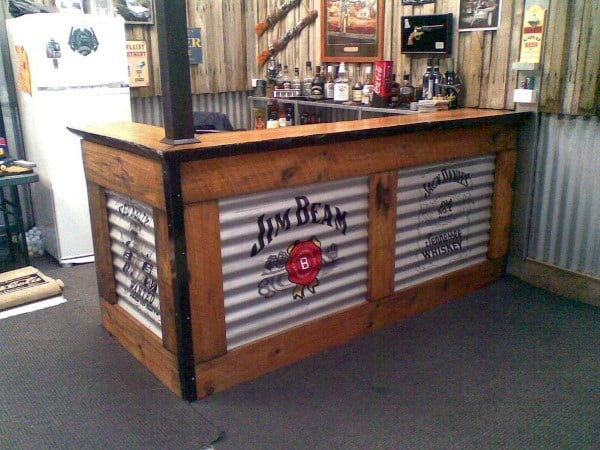 Rustic garage bar with corrugated metal panels, wooden frame, and Jim Beam branding.