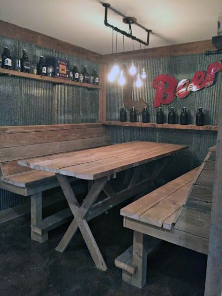 Rustic bar seating area with wooden benches, corrugated metal walls, and beer growler decor.