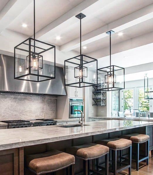 Contemporary kitchen featuring large black square chandeliers above a marble island, with stylish leather bar stools