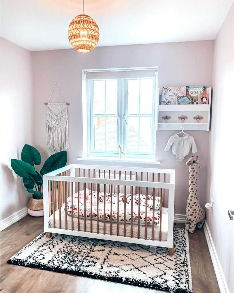 Bright nursery with wooden crib, giraffe plush, and macramé wall hanging in pastel colors.