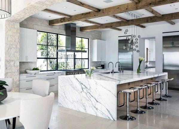 Elegant kitchen with glass crystal ball pendant lights above a marble island, exposed wooden beams, and modern stainless steel appliances