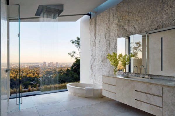 Modern bathroom with open shower, city view, and floating vanity with dual sinks.