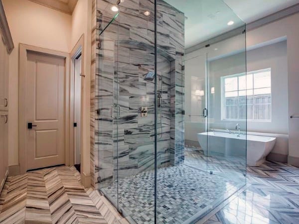 Large marble bathroom with glass shower enclosure and freestanding bathtub.