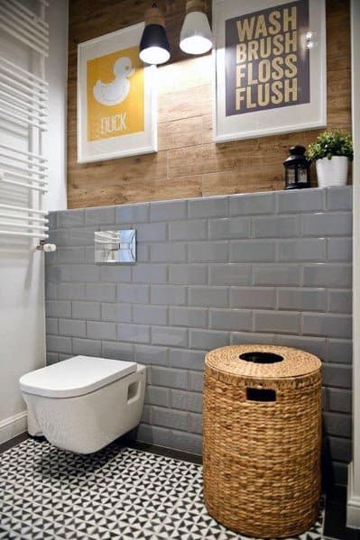 Modern bathroom with wall-hung toilet, wicker laundry bin, and decorative wall art.