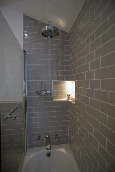 Modern shower with grey subway tiles, a wall niche, and a silver showerhead