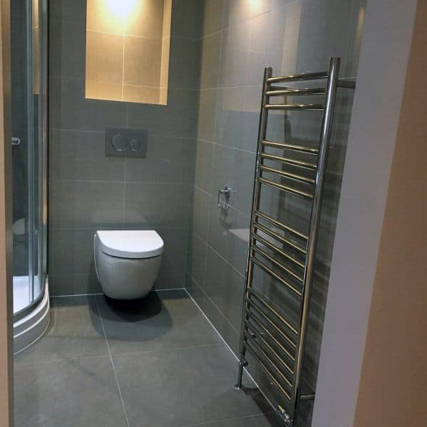 Modern grey bathroom with a wall-mounted toilet, a shower, and a heated towel rack