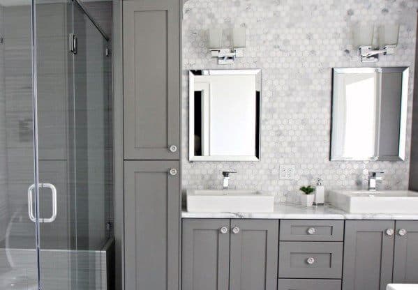 Small hexagon tile backsplash with grey cabinetry and dual vessel sinks in modern bathroom.