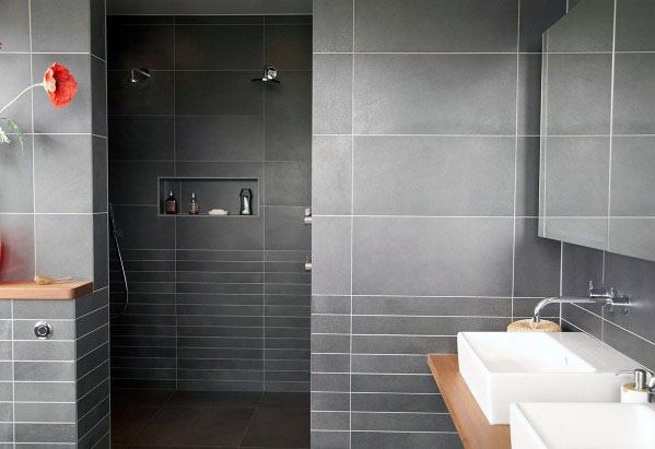 Bathroom with grey cement tile backsplash and a wooden countertop with white vessel sinks.