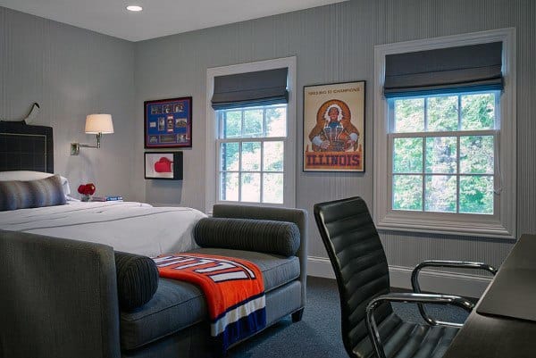 Gray bedroom with Illinois poster, black chair, couch, and wood desk.