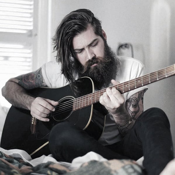 Man with Long Black Beard Playing a Guitar