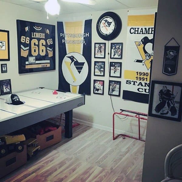 Hockey-themed game room with air hockey table, Pittsburgh Penguins memorabilia, and framed jerseys.