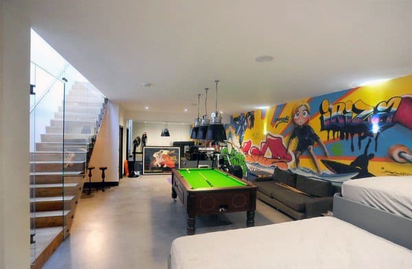 Modern game room with pool table, lounge area, and colorful graffiti wall art.