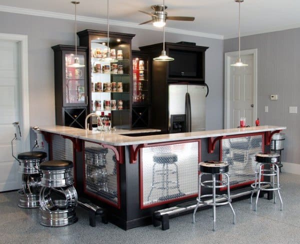 Modern garage bar with metallic accents, tire-inspired stools, and sleek black cabinetry.