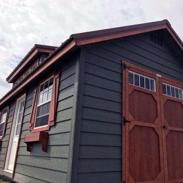 Dark gray pre-fabricated vinyl shed with wooden double doors and windows, featuring a classic design.