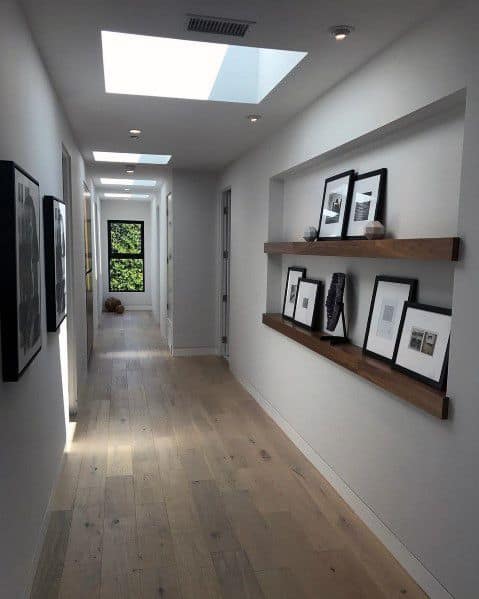 recessed wall shelf in hallway with framed images 