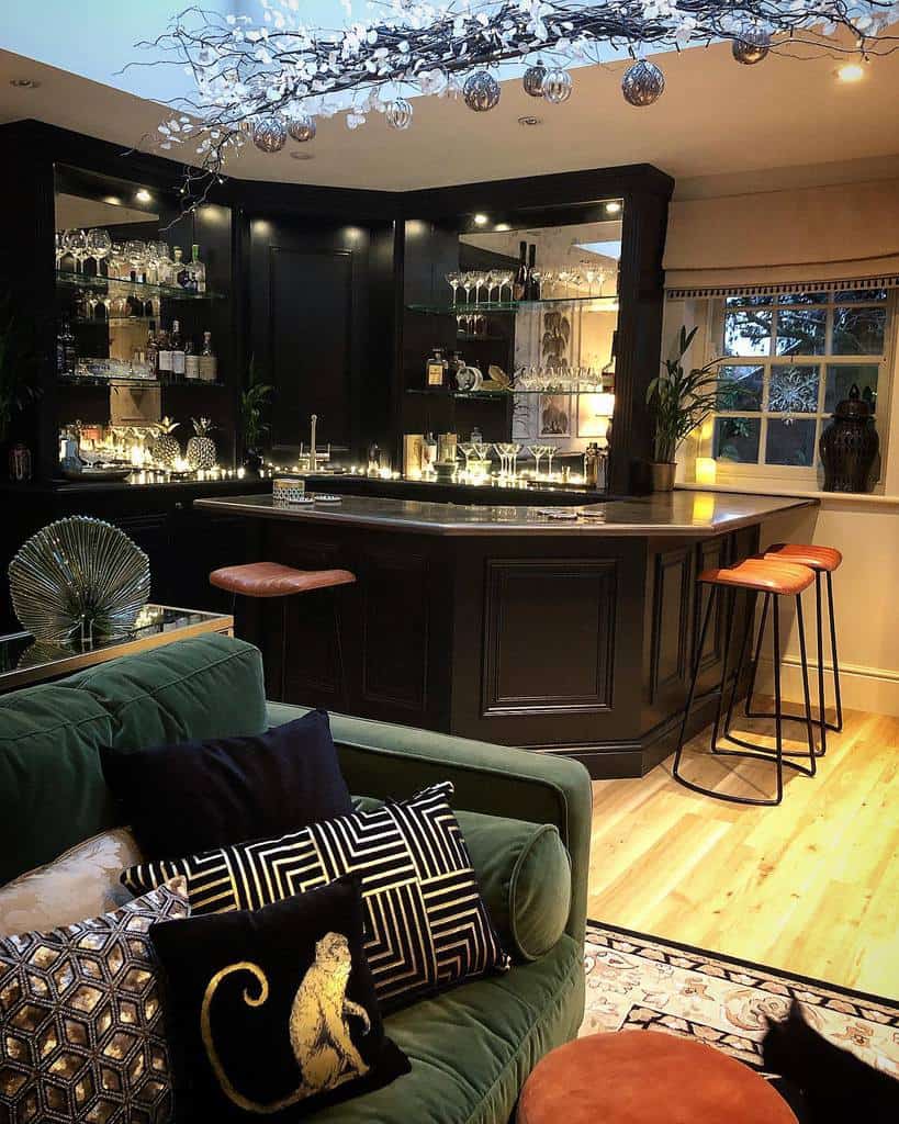 Elegant wet bar with dark cabinets, glass shelves, and cozy lighting.