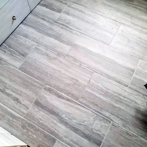 Gray tiled floor with a wood-grain texture in a room corner