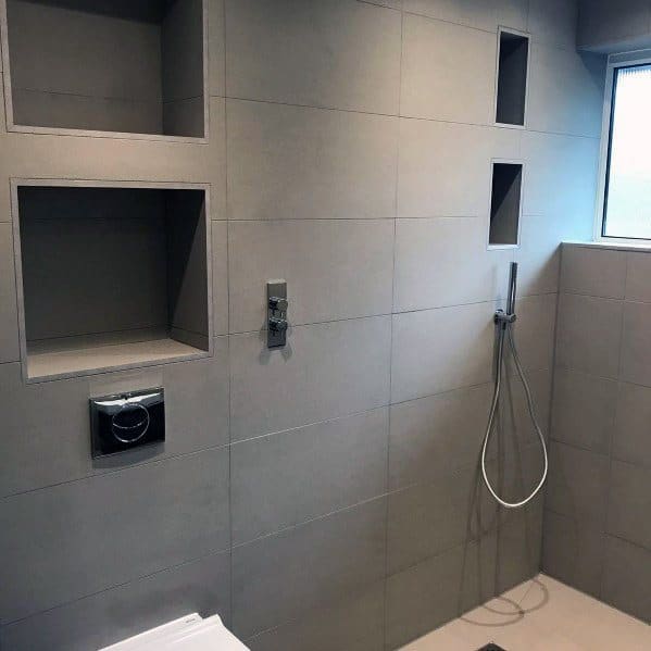 Minimalist grey bathroom with built-in shelves and a wall-mounted showerhead