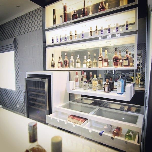 Contemporary mini bar with illuminated shelves, pull-out drawers, and built-in wine fridge.