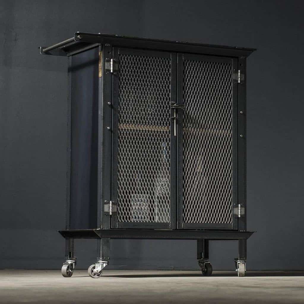 Industrial black metal bar cart with mesh cabinet doors and caster wheels.