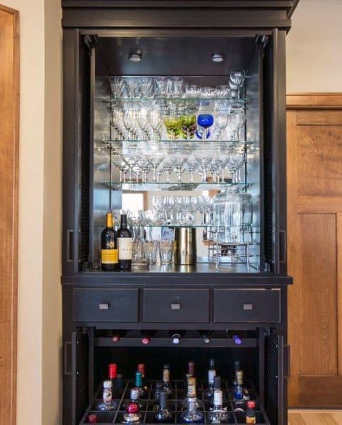 Sophisticated mini bar with black cabinetry, glass shelves, wine storage, and mirrored backing.