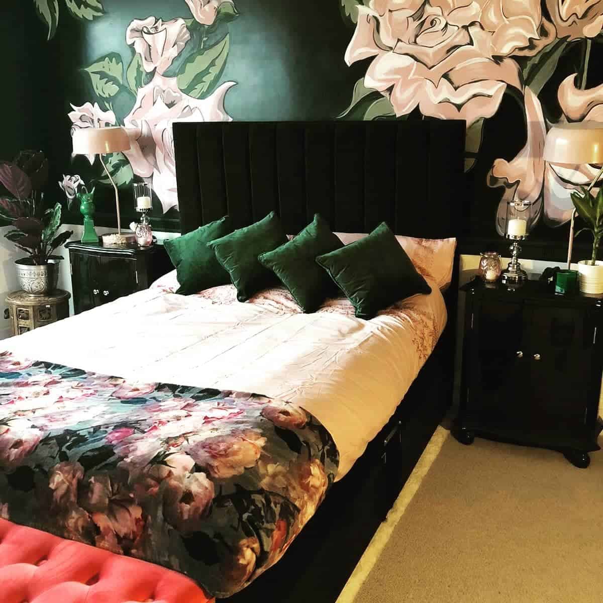 Stylish bedroom with floral wallpaper, a bed with green pillows, and a floral bedspread; two bedside tables with lamps