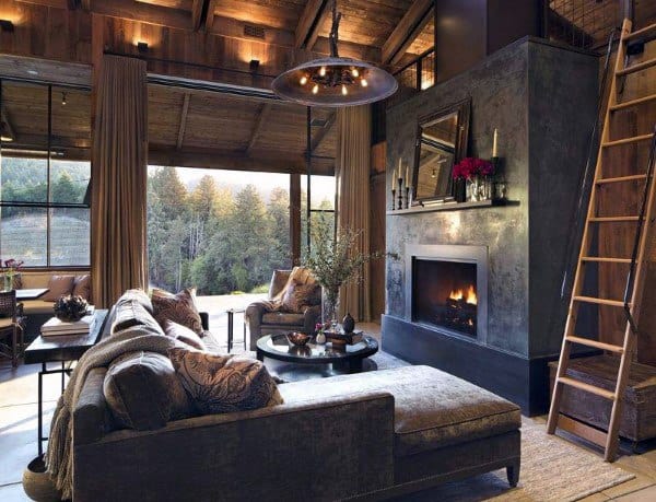 A rustic living room with a modern fireplace, elegant furnishings, and large windows offering scenic views, creating a cozy and inviting atmosphere