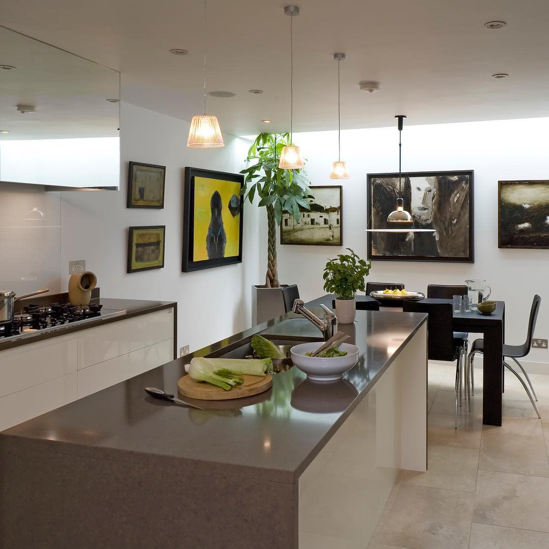 Modern kitchen and dining space with wall art, large island, and pendant lighting.