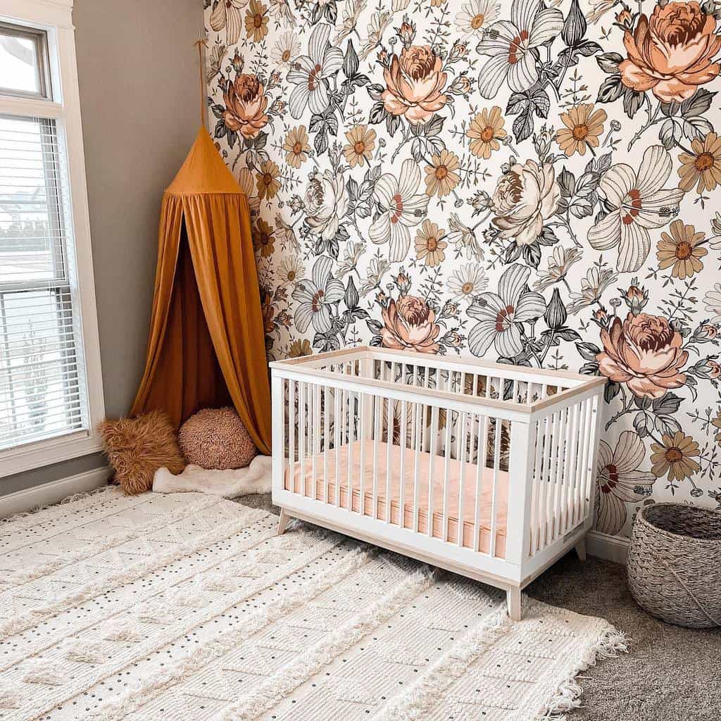 Baby bedroom with floral wallpaper, white crib, orange canopy, and textured rug.