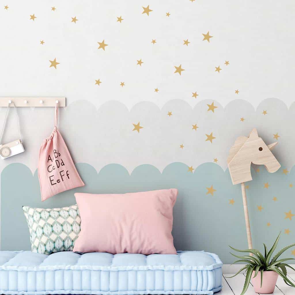 Kids' bedroom with star wallpaper, pink pillows, and a potted plant with wooden decor.