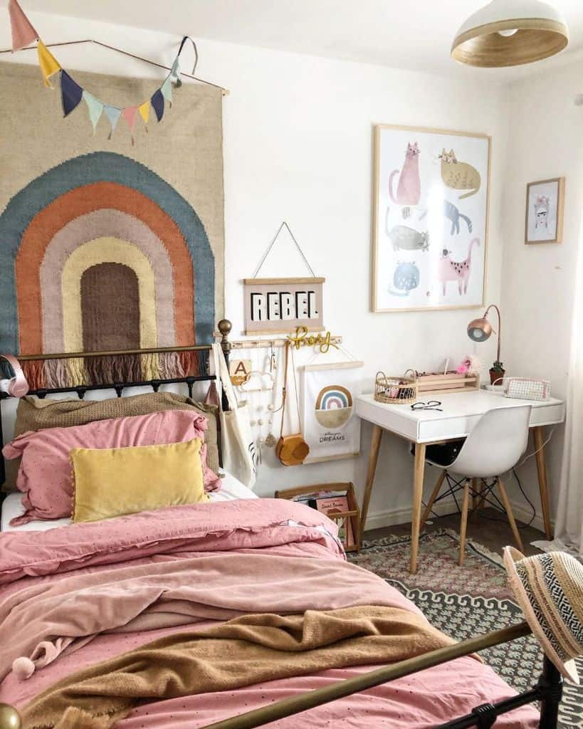 oho kids' room with rainbow wall hanging, cozy pink bedding, and a functional study desk setup.