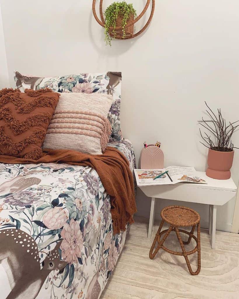 Boho kids' room with floral bedding, earthy tones, woven decor, and a cozy reading nook setup.