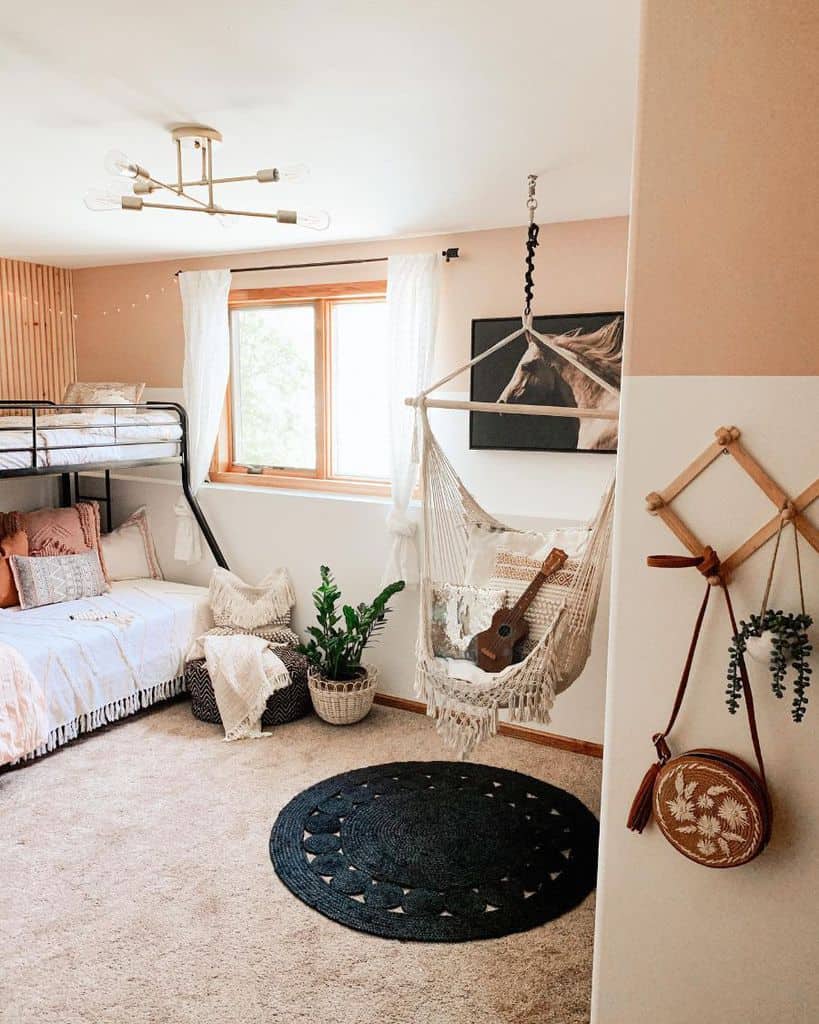 Boho kids' room with bunk bed, macrame swing, black rug, and natural decor elements.