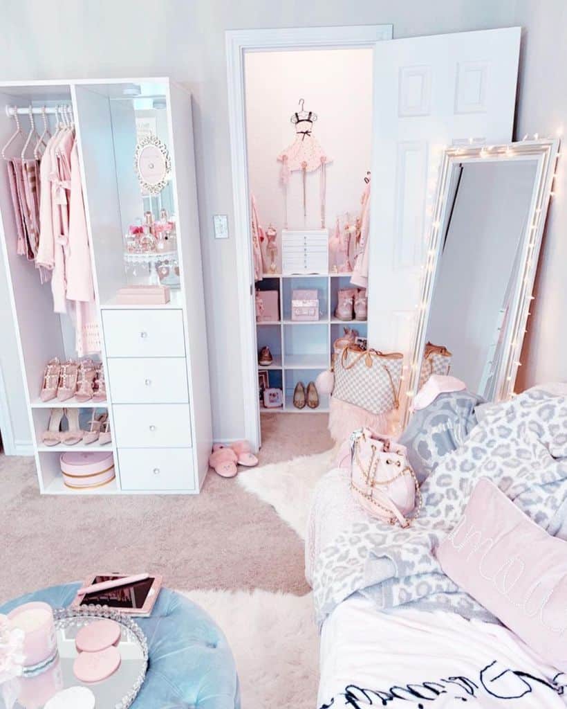 Pink and white bedroom with mirrored wardrobe, open closet, and cozy decor.