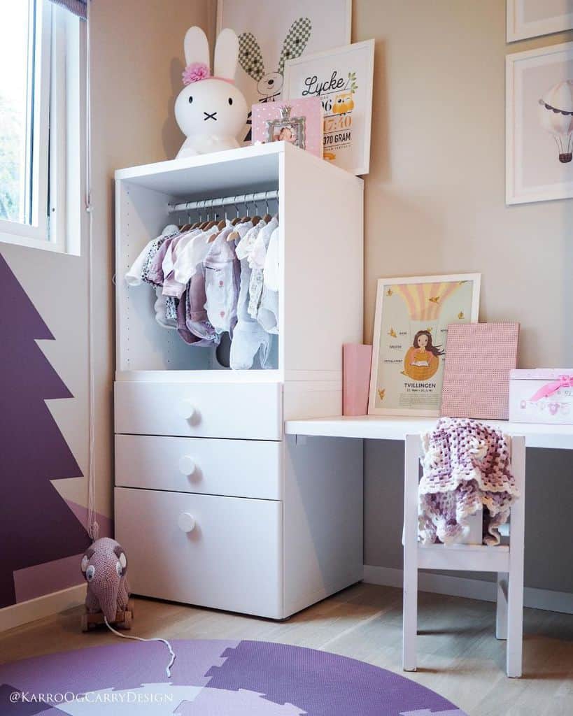 Kids' room with tall storage cupboard, built-in table, and pastel decor accents.