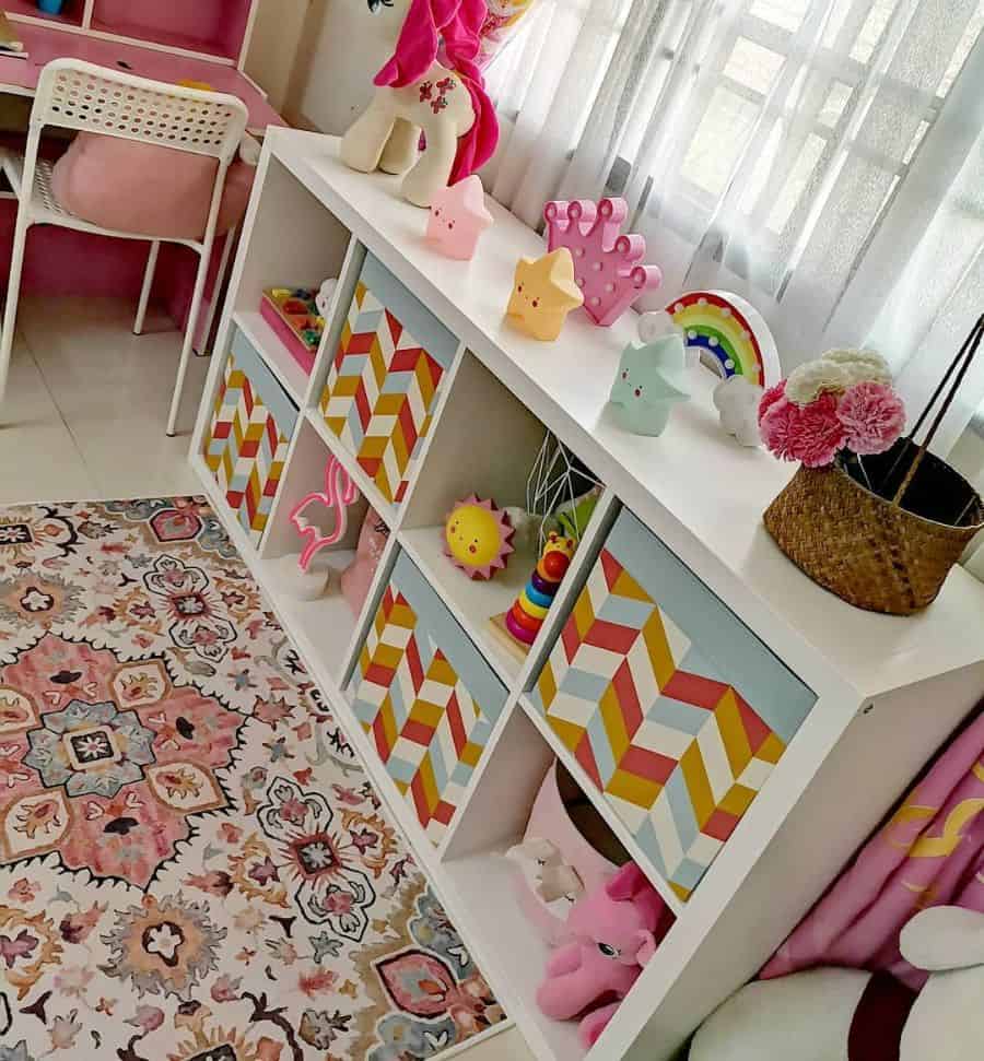 White cubby storage in kids' room with colorful bins and playful decor items.