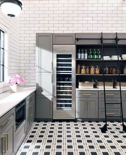 Stylish kitchen with black and white checkered tile flooring, gray cabinetry, open shelving, and a sleek wine fridge, creating a modern and functional space