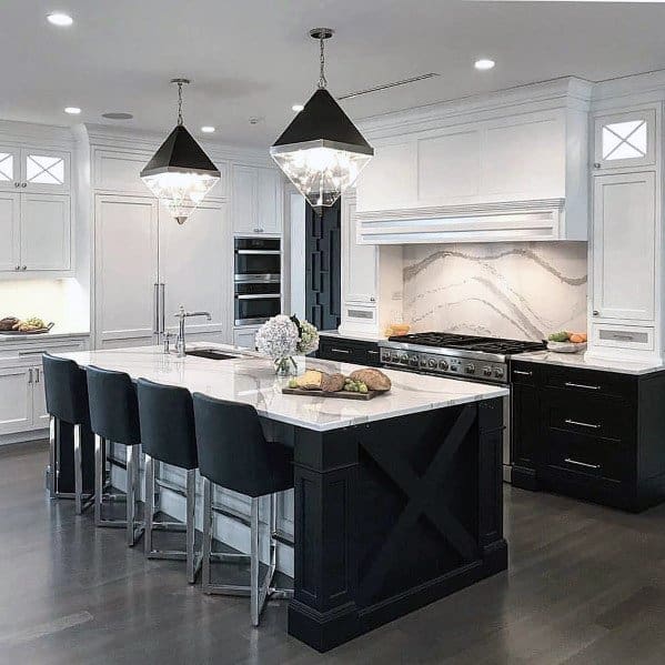 Elegant kitchen with dark hardwood flooring, black and white cabinetry, a stunning marble island countertop, and modern lighting fixtures, creating a sophisticated atmosphere