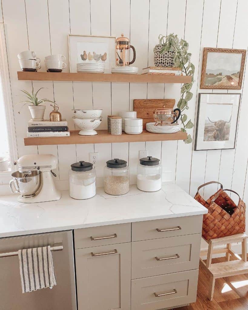 Wooden shelves with mugs, dishes, plants, and jars on a clean countertop.