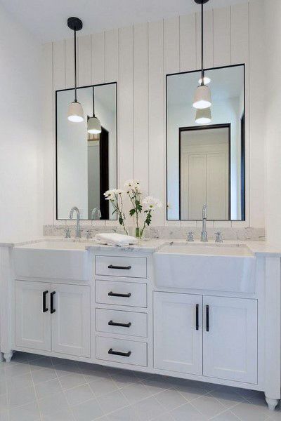 White bathroom with double vanity, farmhouse sink, black accents, and pendant lighting.