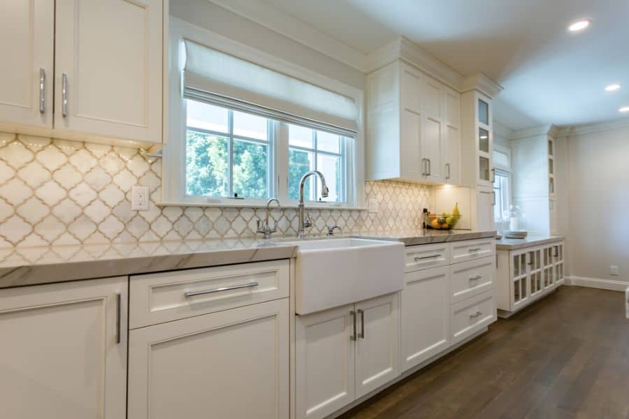 large open and airy white cabinet kitchen with apron sink