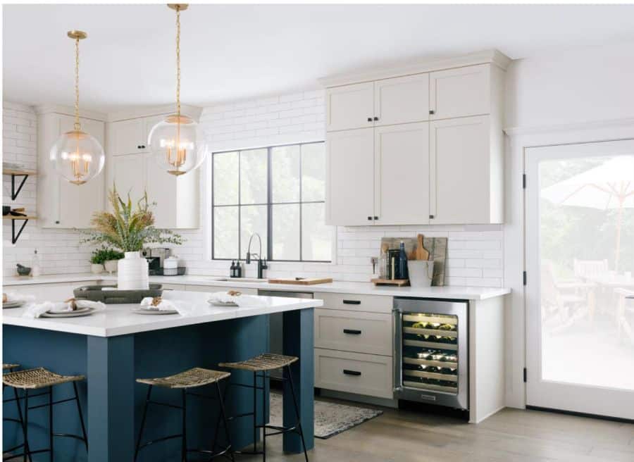 white cabinet kitchen with white tiles and blue island 